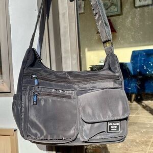Volganik Rock gray nylon cross body bag with side pockets and silver gray zip